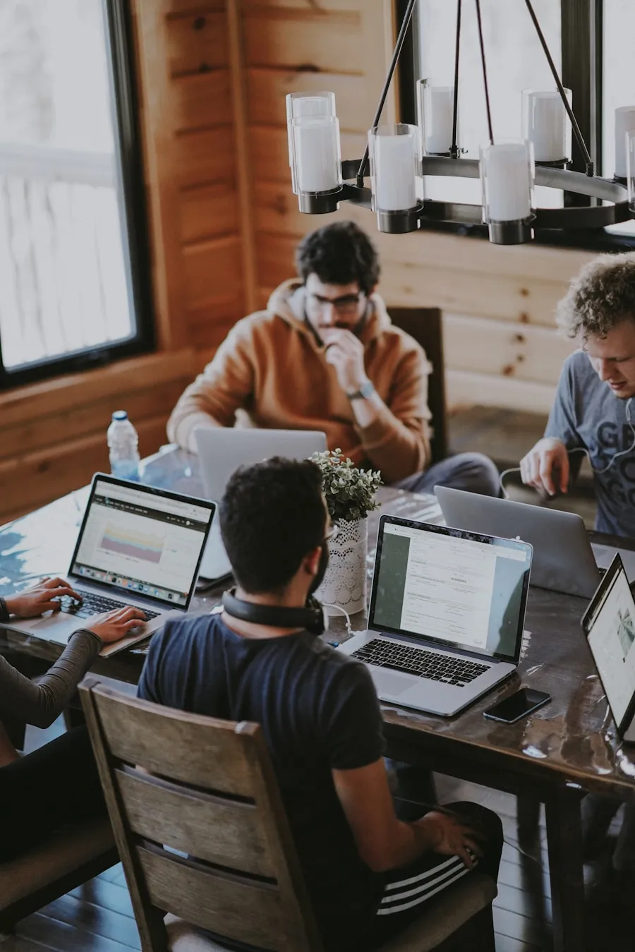 Professionals collaborating around a table with laptops