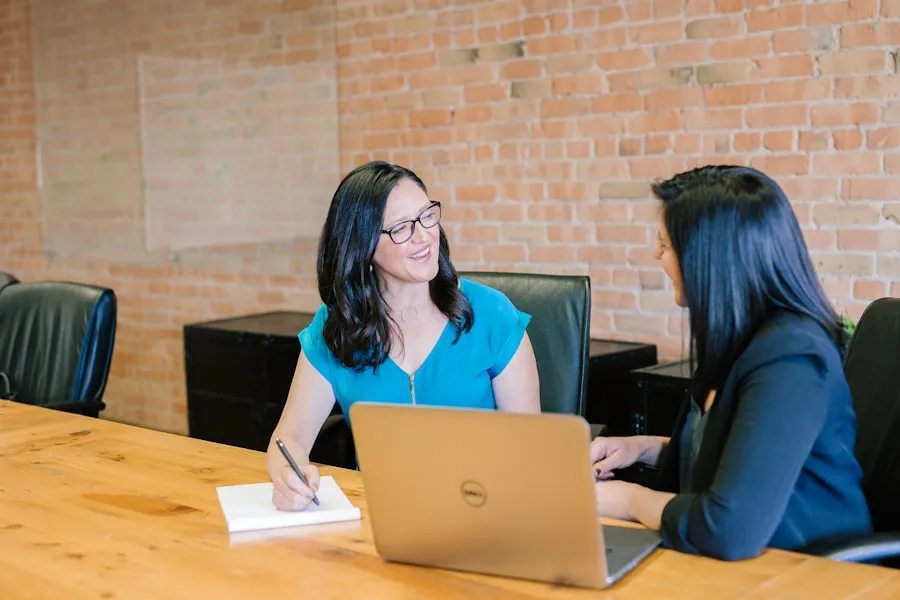 Two women in a focused leadership conversation at a conference table